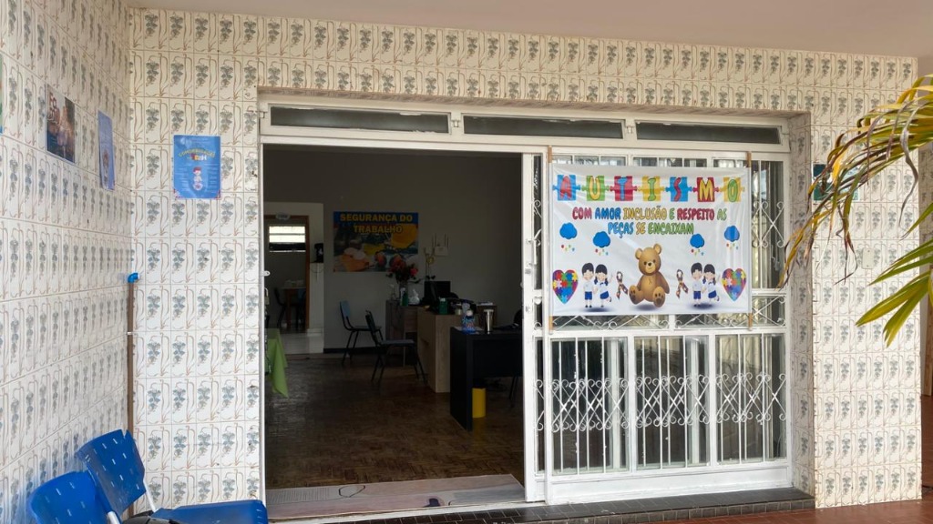 Entrada da clínica com banner de conscientização do autismo – Com Amor, Inclusão e Respeito